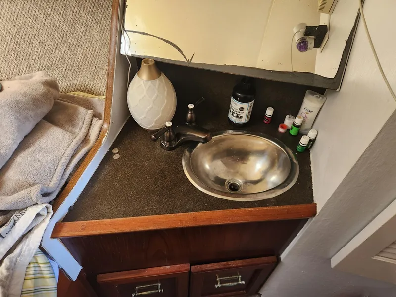 Slide: The Image of 1977 Pacemaker 40 Sportfisherman bathroom sink with toiletries and wooden cabinetry. - 19