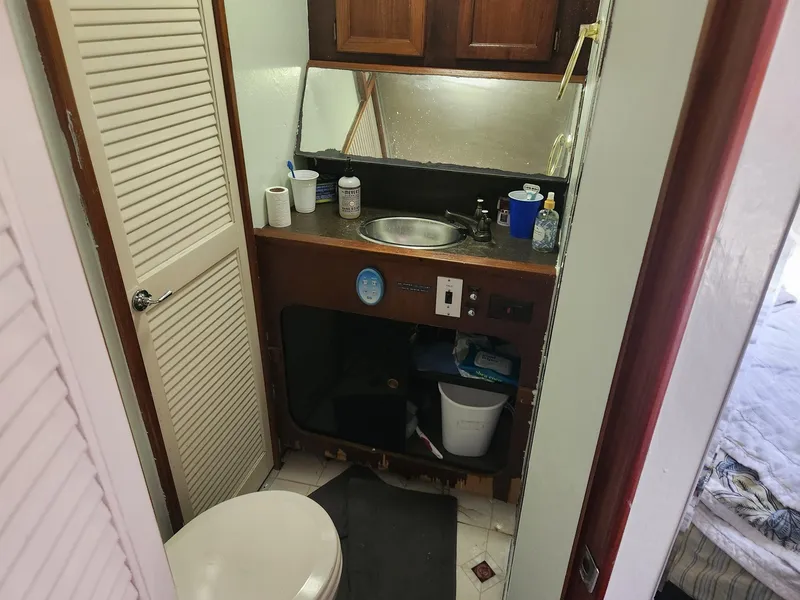 Slide: The Image of 1977 Pacemaker 40 Sportfisherman bathroom with sink, toilet, and storage cabinets. - 20