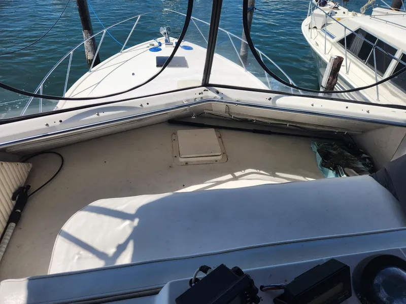 Slide: The Image of 1977 Pacemaker 40 Sportfisherman boat deck with railing, docked beside another vessel. - 6