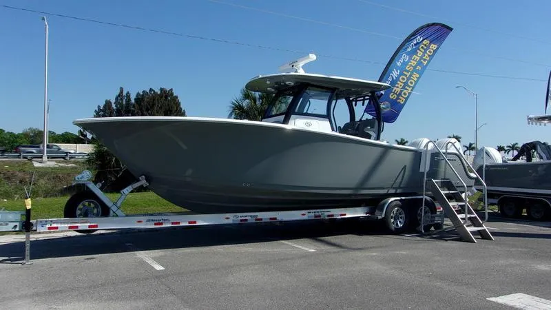 Slide: The Image of 2025 Sportsman Open 302 boat on trailer, displayed outdoors with a promotional flag. - 0