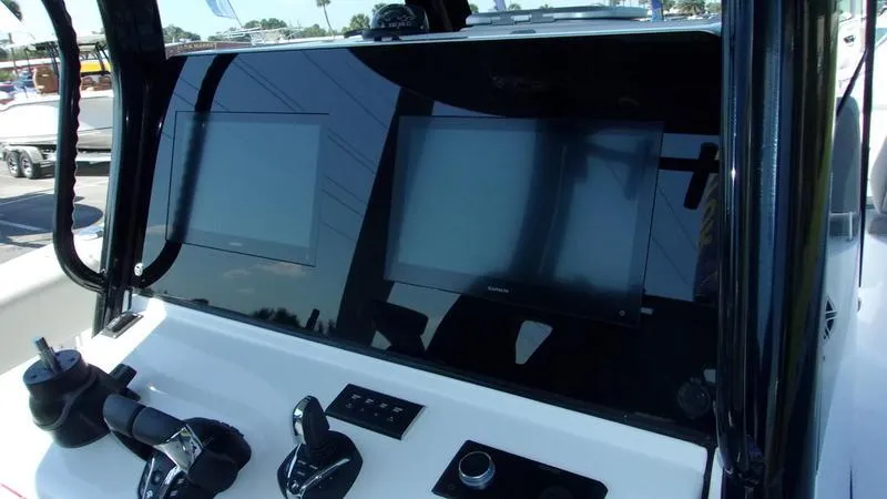 Slide: The Image of 2025 Sportsman Open 302 boat dashboard with dual screens and controls. - 10