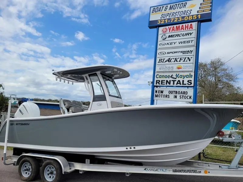 Slide: The Image of 2025 Sportsman Open 232 boat on trailer at dealership with signage in background. - 0