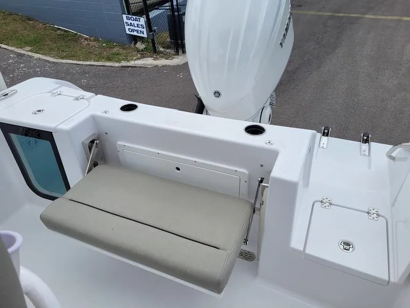 Slide: The Image of 2025 Sportsman Open 232 boat with foldable seat and motor, near boat sales area. - 1