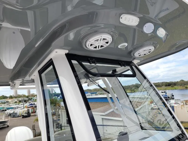Slide: The Image of 2025 Sportsman Open 232 boat interior with speakers and controls, docked near a marina. - 10