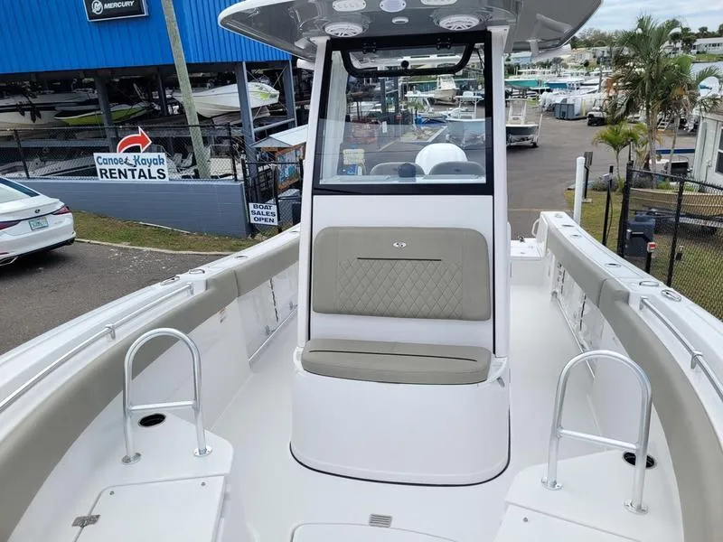 Slide: The Image of 2025 Sportsman Open 232 boat interior with seating and console, docked near rental shop. - 9
