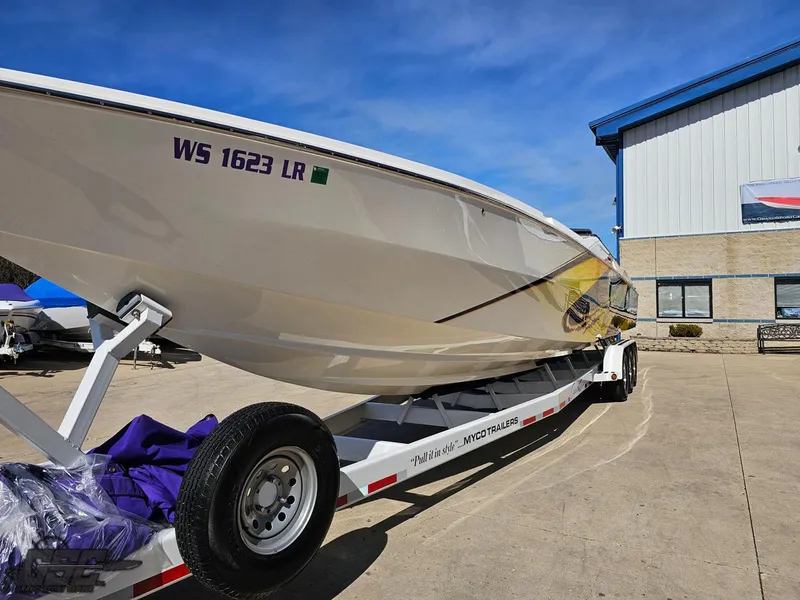 Slide: The Image of 2003 Cigarette 42 Tiger boat on trailer, parked outside a building under clear blue sky. - 16