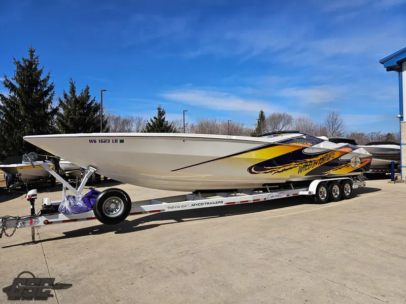 Slide: The Image of 2003 Cigarette 42 Tiger speedboat on trailer, vibrant graphics, parked outdoors under clear sky. - 17
