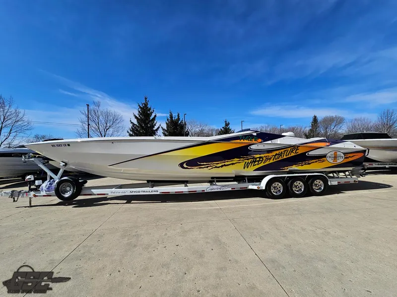 Slide: The Image of 2003 Cigarette 42 Tiger speedboat on trailer, vibrant graphics, clear blue sky background. - 20