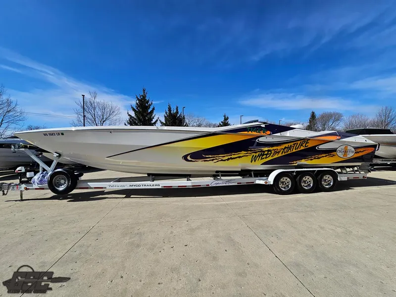 Slide: The Image of 2003 Cigarette 42 Tiger speedboat on trailer, vibrant graphics, clear blue sky background. - 21