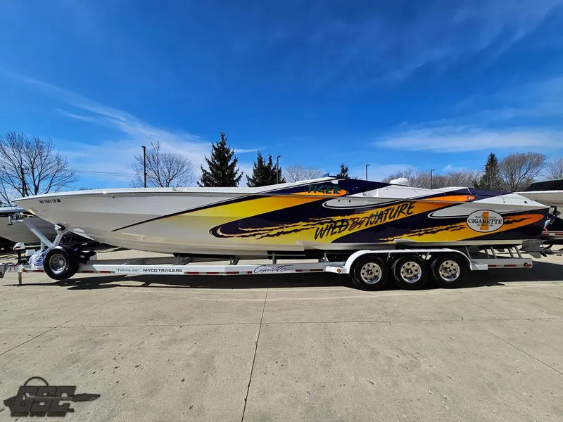 Slide: The Image of 2003 Cigarette 42 Tiger speedboat on trailer, vibrant graphics, clear sky background. - 22