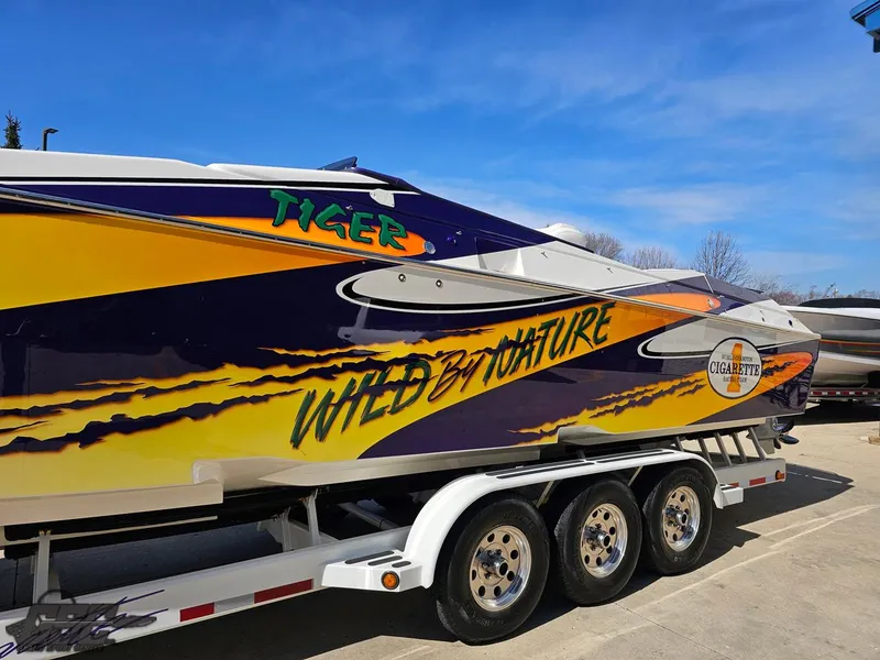 Slide: The Image of 2003 Cigarette 42 Tiger boat with vibrant "Wild by Nature" graphics on trailer. - 23