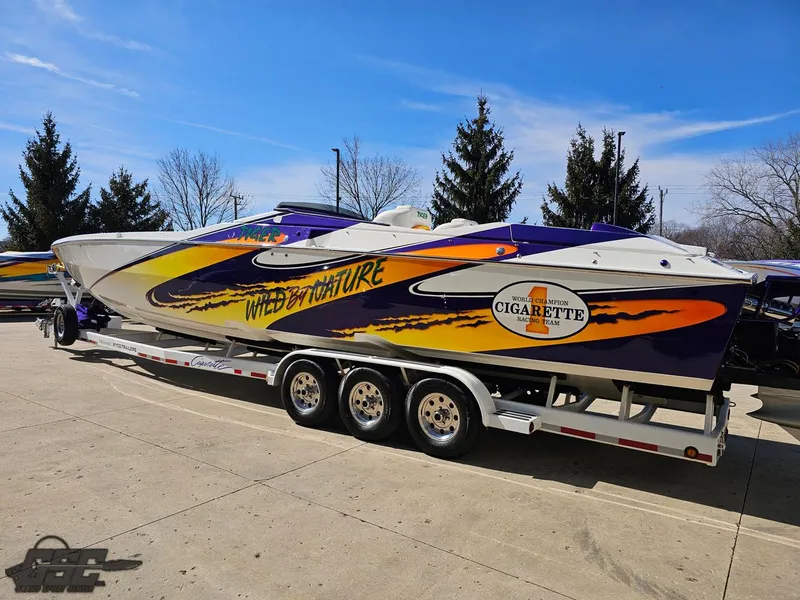 Slide: The Image of 2003 Cigarette 42 Tiger speedboat with vibrant graphics on a trailer. - 30