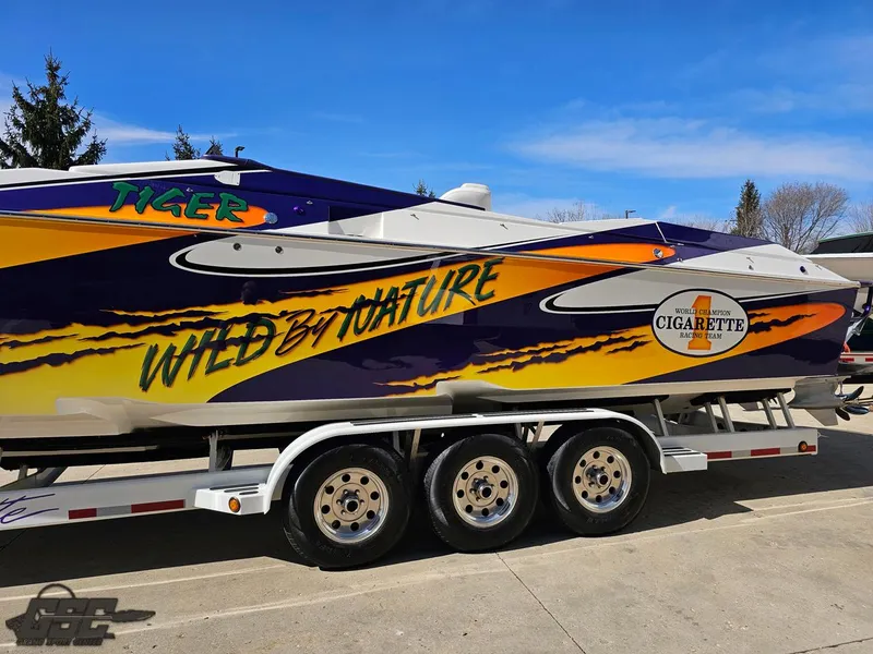 Slide: The Image of 2003 Cigarette 42 Tiger boat with vibrant graphics on a trailer. - 31