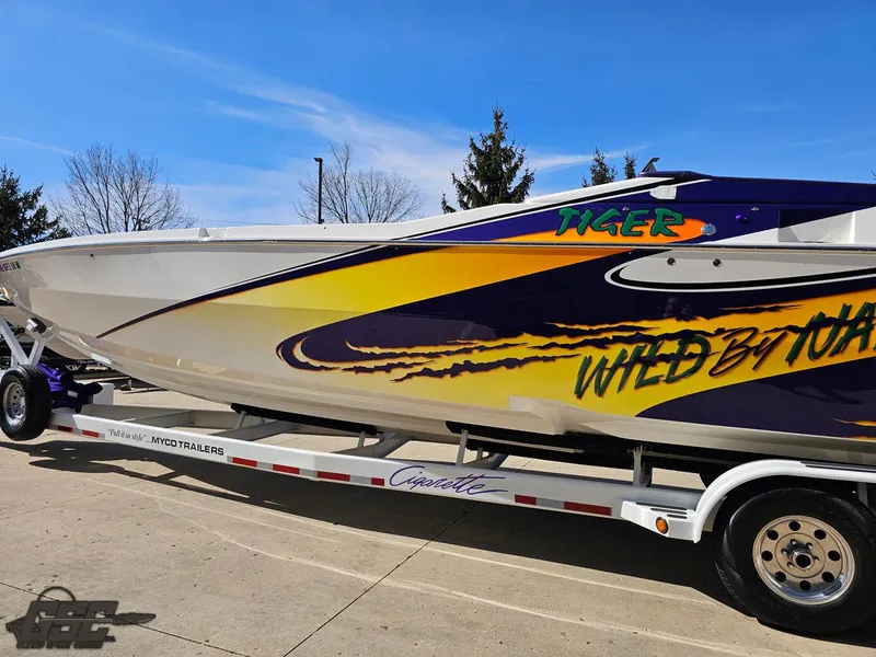 Slide: The Image of 2003 Cigarette 42 Tiger speedboat with vibrant graphics on a trailer. - 32
