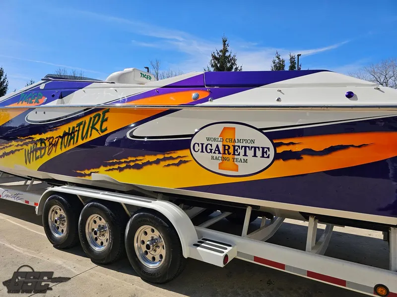 Slide: The Image of 2003 Cigarette 42 Tiger speedboat with vibrant graphics on a trailer. - 34