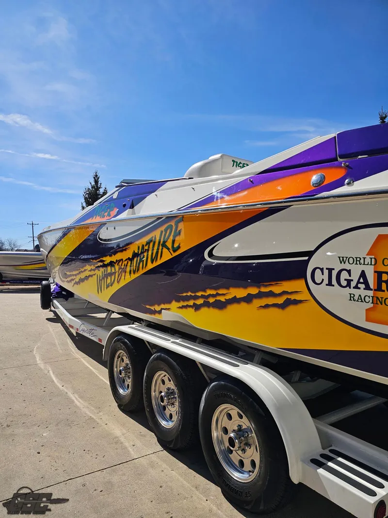 Slide: The Image of 2003 Cigarette 42 Tiger boat with vibrant graphics on a trailer. - 36