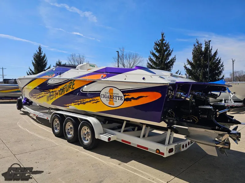 Slide: The Image of 2003 Cigarette 42 Tiger powerboat with vibrant graphics on a trailer, parked outdoors. - 37