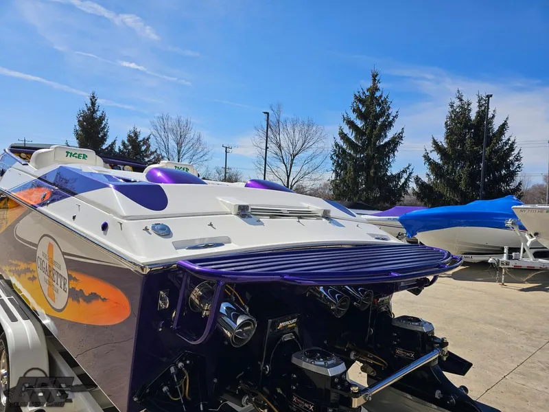 Slide: The Image of 2003 Cigarette 42 Tiger boat with vibrant purple and white design, parked outdoors. - 39
