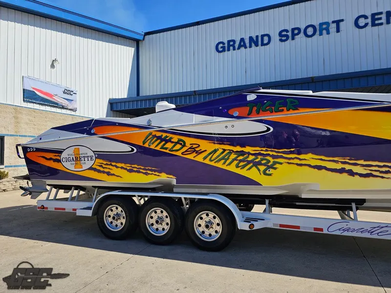 Slide: The Image of 2003 Cigarette 42 Tiger powerboat with vibrant graphics, parked at Grand Sport Center. - 4