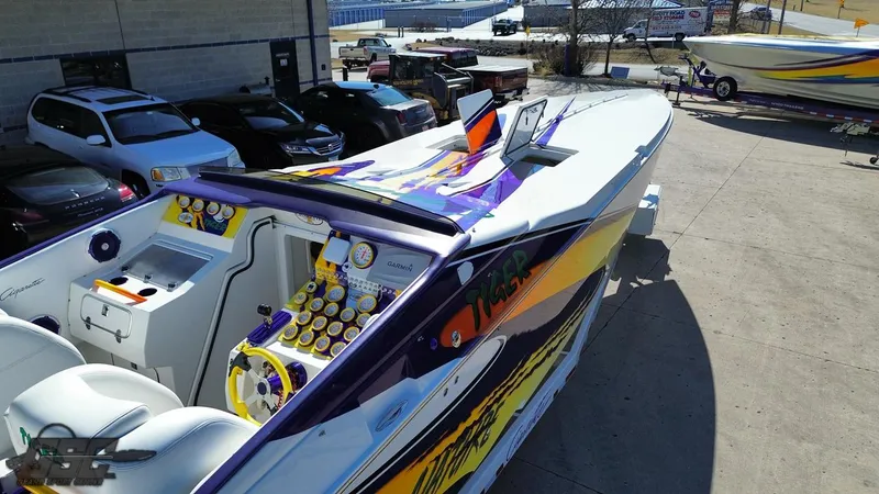 Slide: The Image of 2003 Cigarette 42 Tiger speedboat with vibrant purple and yellow design, parked outdoors. - 47
