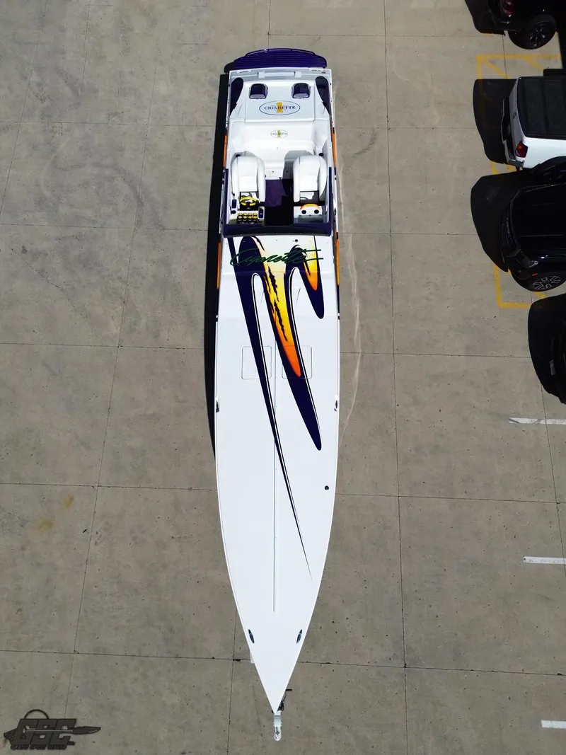 Slide: The Image of 2003 Cigarette 42 Tiger speedboat with vibrant graphics, parked on concrete surface. - 49