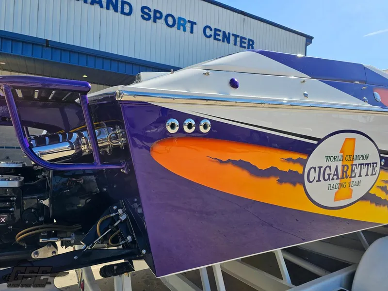 Slide: The Image of 2003 Cigarette 42 Tiger boat with vibrant racing graphics at a sport center. - 9