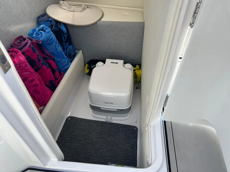 Slide: The Image of 2020 Cobalt R5 Surf boat interior with portable toilet and colorful towels. - 15