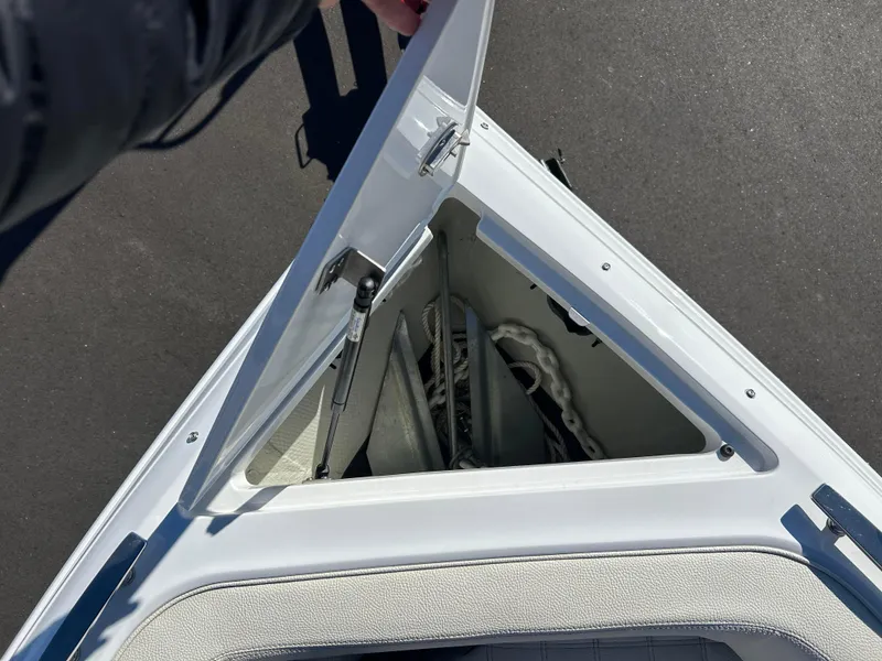 Slide: The Image of 2020 Cobalt R5 Surf boat anchor storage compartment open, showing anchor and rope. - 18