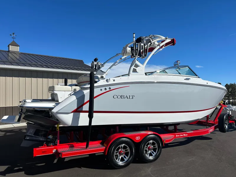 Slide: The Image of 2020 Cobalt R5 Surf boat on red trailer, parked outdoors. - 5