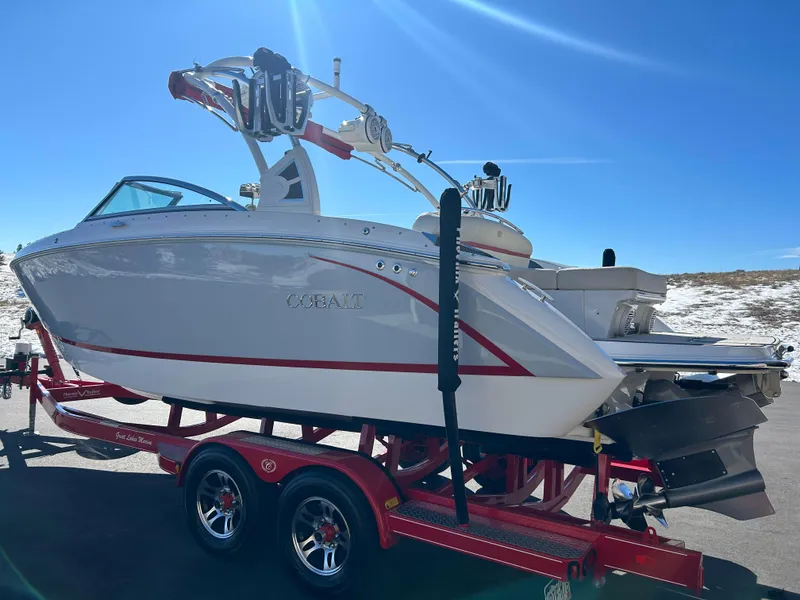 Slide: The Image of 2020 Cobalt R5 Surf boat on red trailer under clear blue sky. - 7