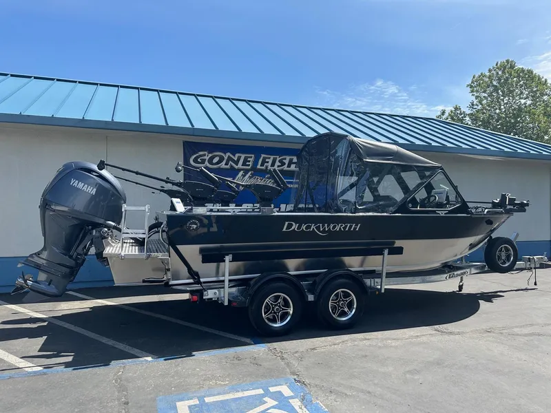 Slide: The Image of 2025 Duckworth 20 Advantage boat with Yamaha engine on trailer, parked outside a building. - 0
