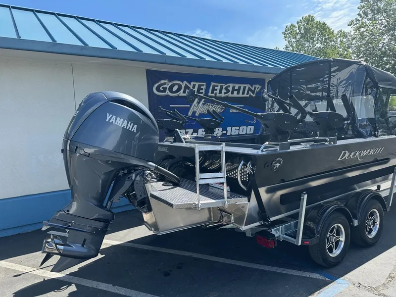Slide: The Image of 2025 Duckworth 20 Advantage boat with Yamaha engine, parked outside a fishing store. - 1
