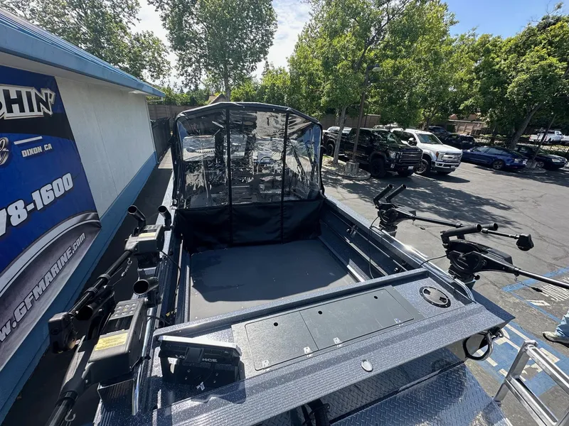 Slide: The Image of 2025 Duckworth 20 Advantage boat with canopy, parked outdoors near dealership. - 5