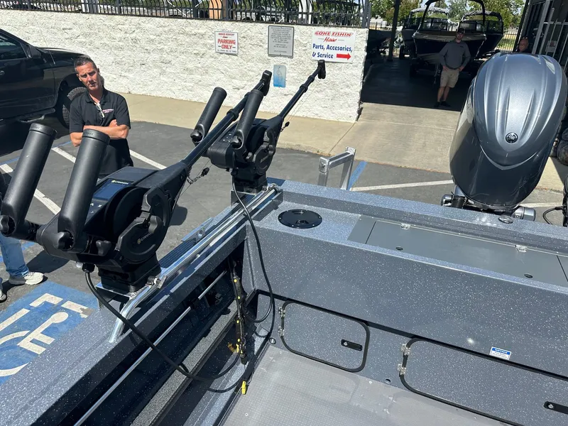 Slide: The Image of 2025 Duckworth 20 Advantage boat with fishing rod holders and outboard motor in a dealership. - 7
