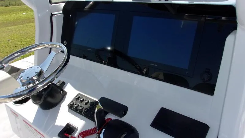 Slide: The Image of 2025 Sportsman Open 232 boat dashboard with dual screens and steering wheel. - 8