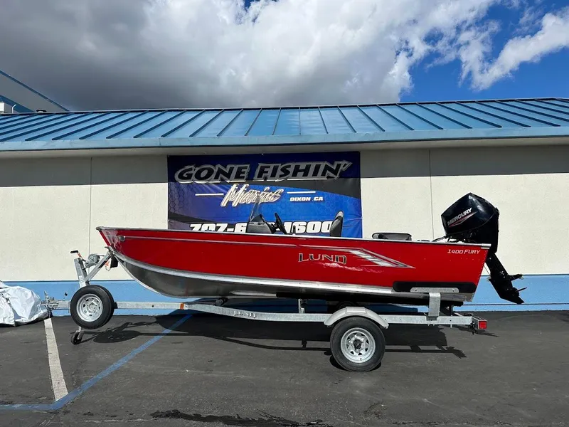 Slide: The Image of 2025 Lund 1400 Fury SS boat on trailer, displayed outdoors. - 0