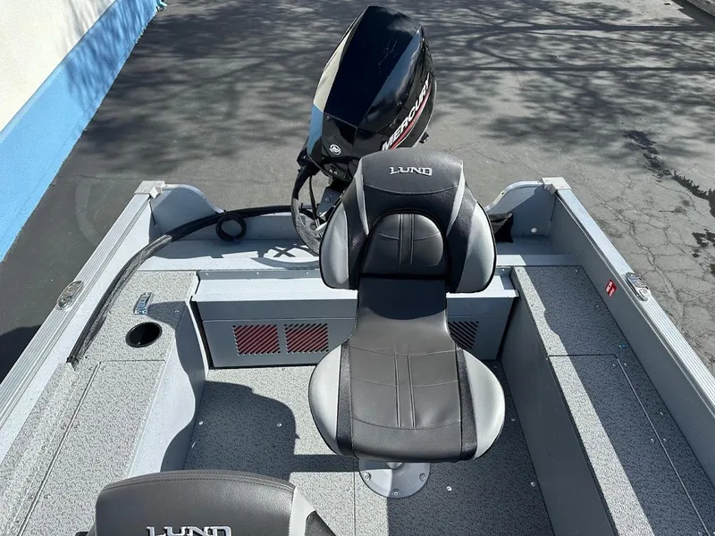 Slide: The Image of 2025 Lund 1400 Fury SS boat interior with seating and motor. - 10