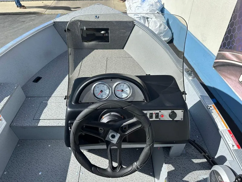 Slide: The Image of 2025 Lund 1400 Fury SS boat dashboard with steering wheel and gauges. - 12