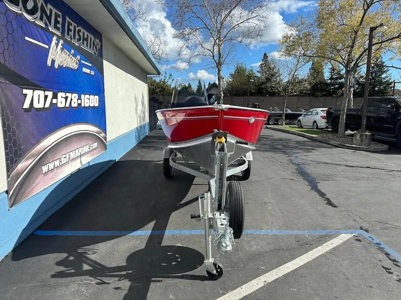 Slide: The Image of 2025 Lund 1400 Fury SS boat on trailer in parking lot, sunny day. - 2