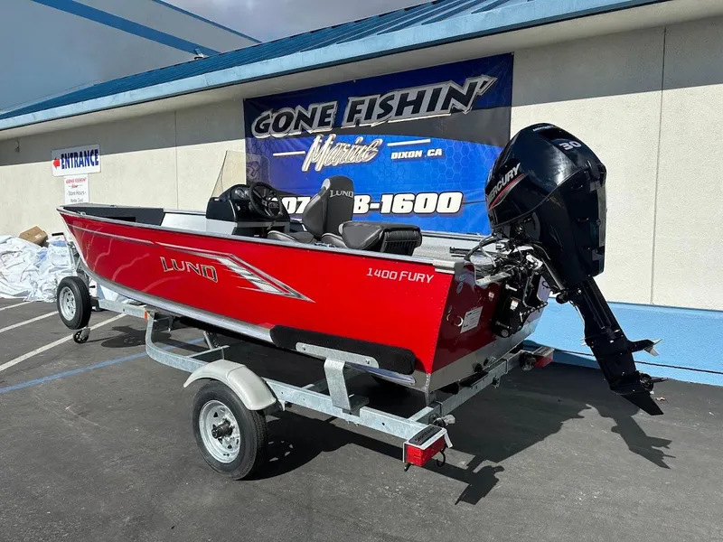 Slide: The Image of 2025 Lund 1400 Fury SS boat on trailer, red exterior, displayed outdoors. - 6
