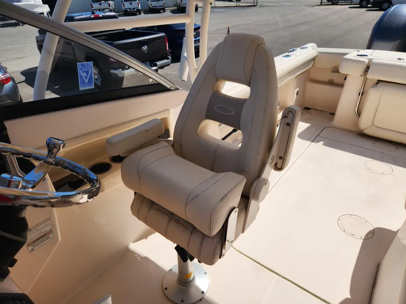 Slide: The Image of 2015 Grady-White Freedom 275 boat interior with captain's chair and steering wheel. - 13
