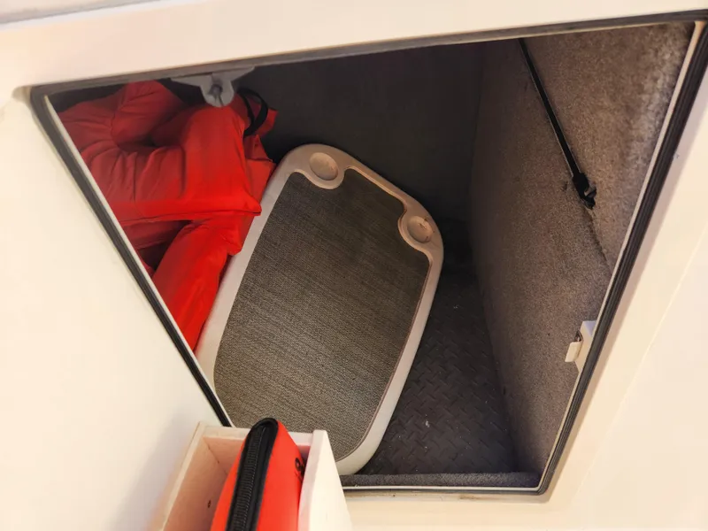 Slide: The Image of Storage compartment in a 2015 Grady-White Freedom 275 boat with life jackets and a table. - 18