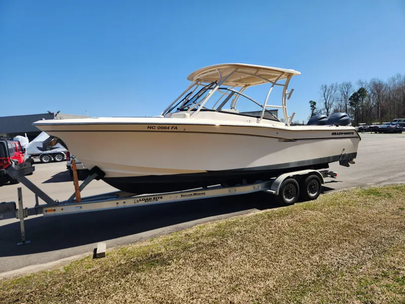 Slide: The Image of 2015 Grady-White Freedom 275 boat on trailer, parked outdoors under clear blue sky. - 7