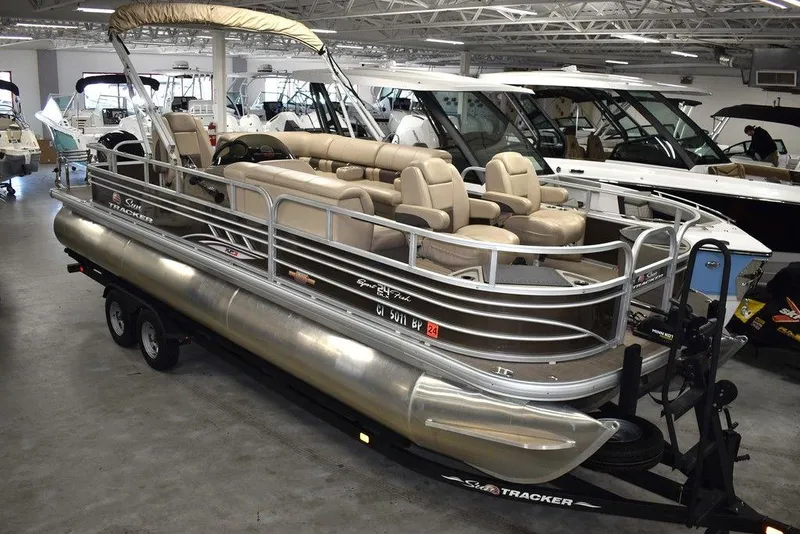 The Image of 2023 Sun Tracker Sportfish™ 24 XP3 pontoon boat in showroom, featuring spacious seating and sleek design. - 1