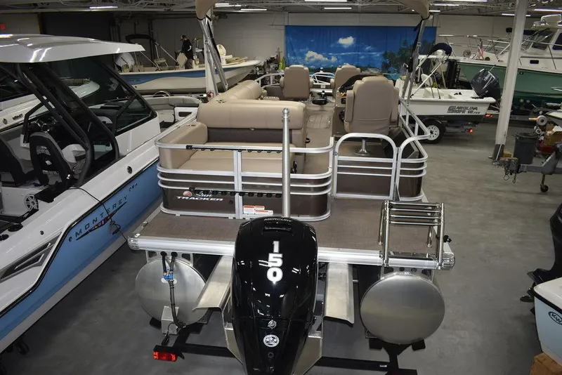 Slide: The Image of 2023 Sun Tracker Sportfish™ 24 XP3 pontoon boat in showroom, rear view with 150 HP engine. - 13