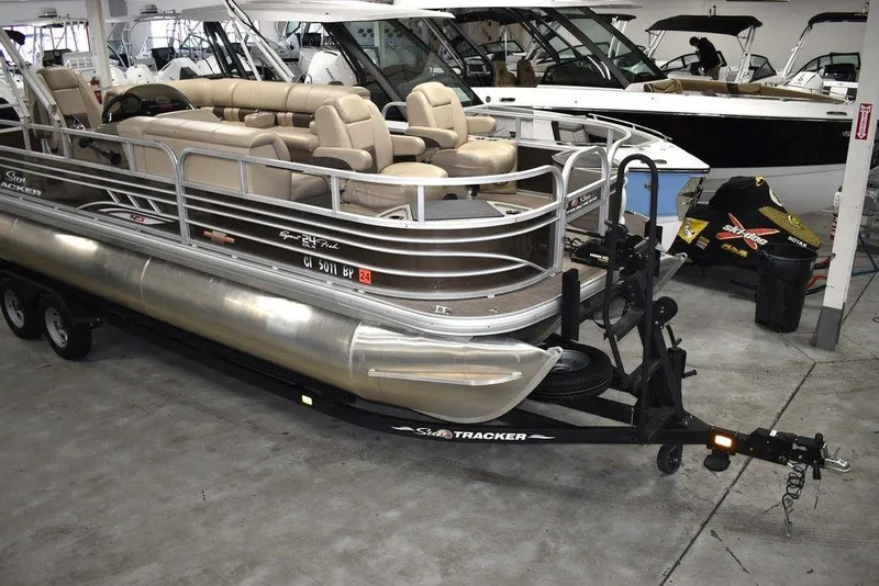 Slide: The Image of 2023 Sun Tracker Sportfish™ 24 XP3 pontoon boat in showroom, featuring spacious seating. - 4