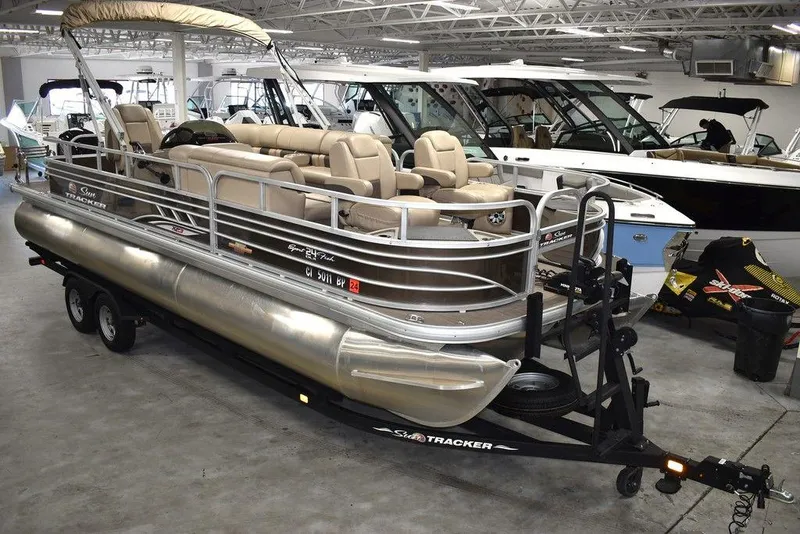 Slide: The Image of 2023 Sun Tracker Sportfish™ 24 XP3 pontoon boat in showroom, featuring beige seating and sleek design. - 5
