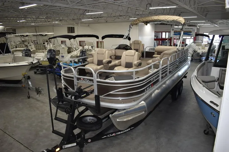 Slide: The Image of 2023 Sun Tracker Sportfish™ 24 XP3 pontoon boat displayed in a showroom. - 6