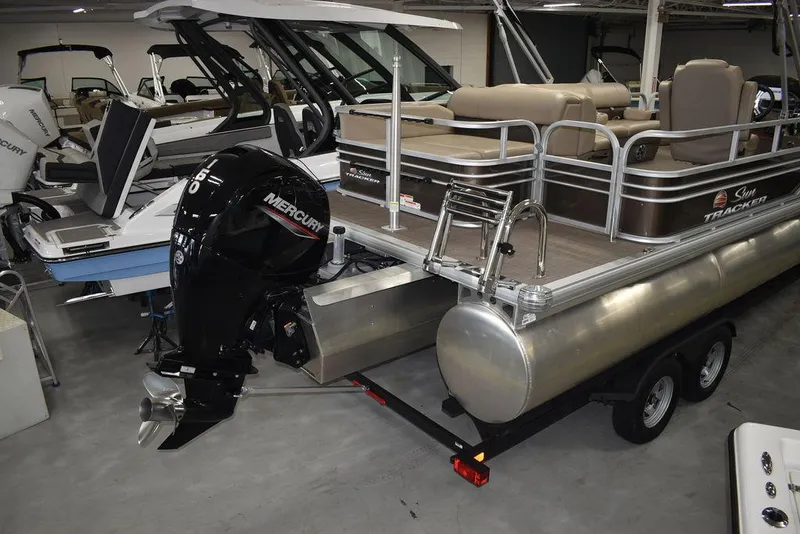 Slide: The Image of 2023 Sun Tracker Sportfish™ 24 XP3 pontoon boat with Mercury outboard motor in showroom. - 9