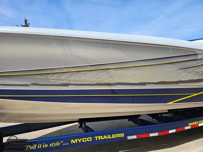 Slide: The Image of 2007 Outerlimits 39 Quattro boat on Myco trailer, sleek design with blue and yellow accents. - 15